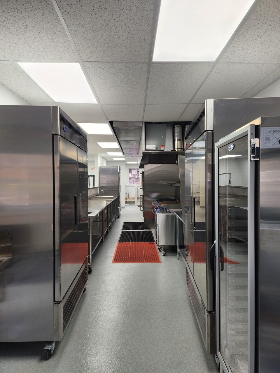 Aisle lined with stainless steel commercial fridges